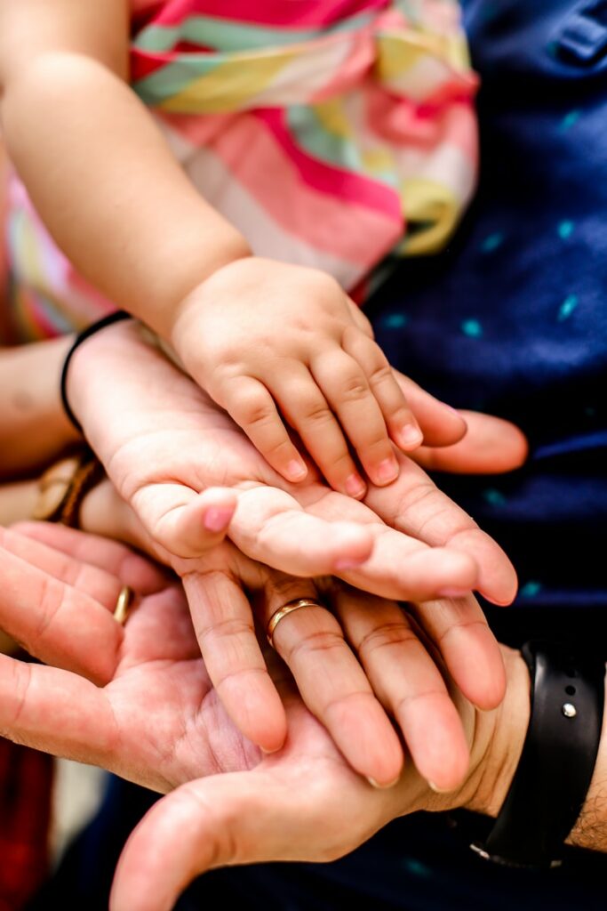 person wearing black watch holding babys hand, Familie als Lernumfeld