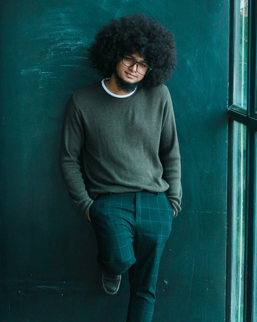 Young Man with Afro Hair and Eyeglasses Standing Against a Blackboard, Persönlichkeit und Selbstfindung