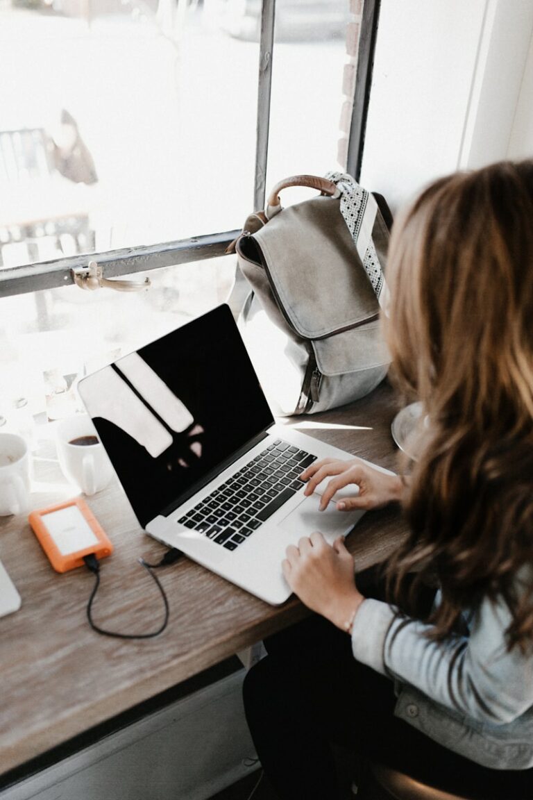 girl wearing grey long-sleeved shirt using MacBook Pro on brown wooden table, Smarte Strategien für deinen Lerntyp​